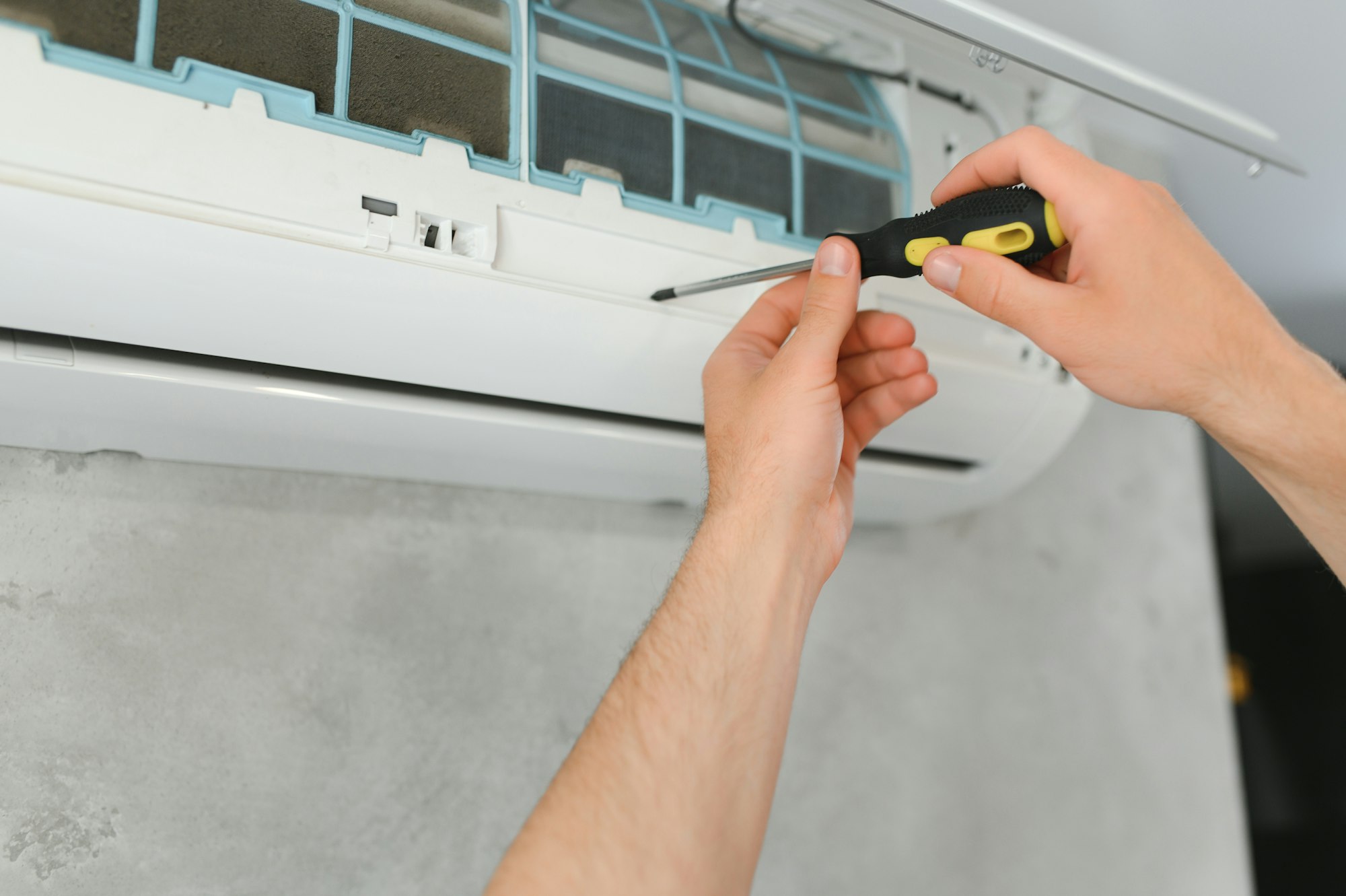 Portrait Of A Young Man Adjusting Air Conditioning System